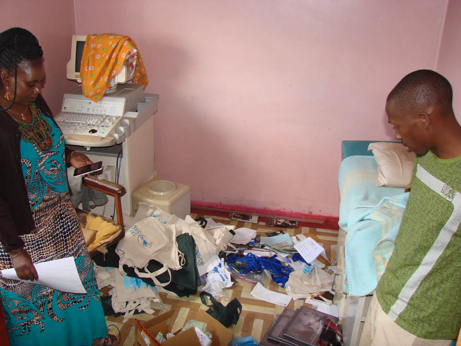 Barbra Mwansa and a fellow leader look through the wreckage left from a recent robbery