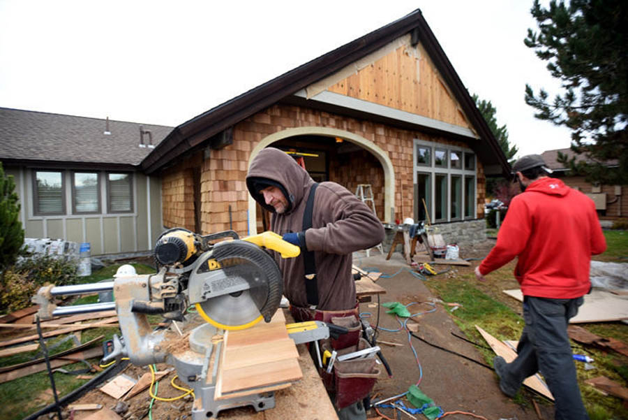 Joel Jetty of Kramer Enterprises Inc cuts shingles for the exterior of the newly renovated Clear Choice Clinic on Friday afternoon, Oct. 21, in Kalispell. The clinic has expanded both their space and their services.