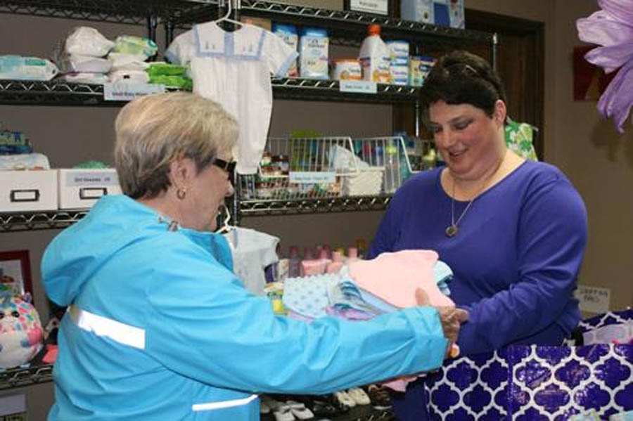 Melissa Ziegenhorn is known as the "Blanket Lady" at Arkansas Pregnancy Resource Center. She's seen here handing off blankets to center volunteer Joan Wehr. 