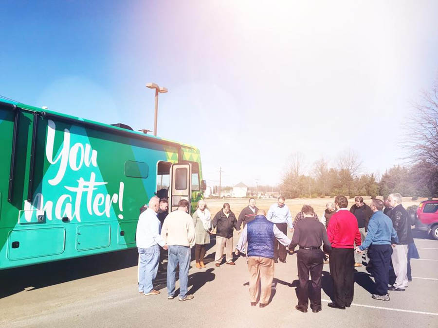 Volunteers and staff pray to dedicate HELP's mobile ultrasound unit, which they would use to save Kaitlyn's baby's life.