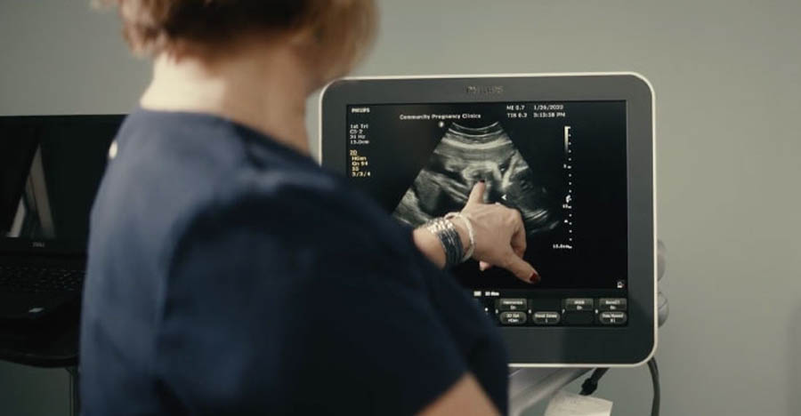 A staffer at a pro-life Community Pregnancy Clinic examines an ultrasound image of an unborn child.