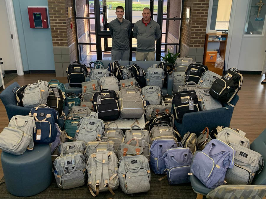 University of Cincinnati Bearcats staff with diaper bag donations for a local pregnancy help center