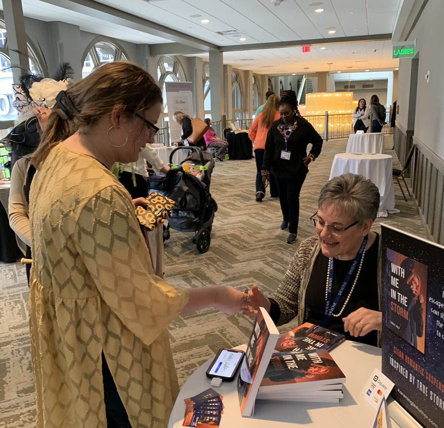 Author Karen Ingle speaks with a Conference attendee at Writers Row