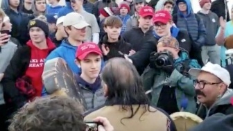 Covington Catholic High School Junior Nick Sandmann keeps his cool as protester Nathan Phillips approaches.